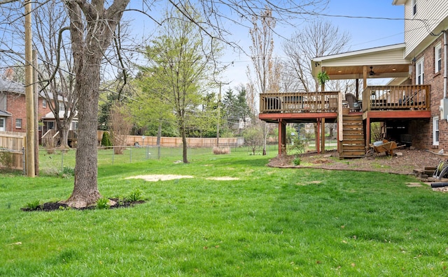view of yard with stairway, a deck, fence, and a ceiling fan