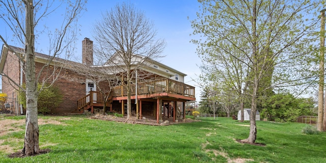rear view of house featuring a wooden deck, fence, a chimney, a storage shed, and stairway