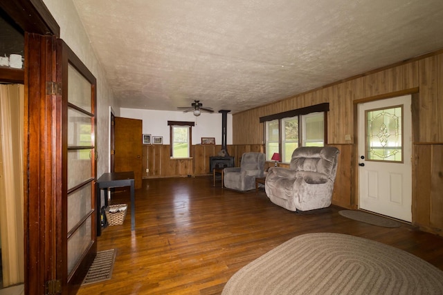 534 Lower Gilmore Rd, Campton, KY 41301 - living room featuring a textured ceiling, visible vents, a wood stove, wood finished floors, and wooden walls