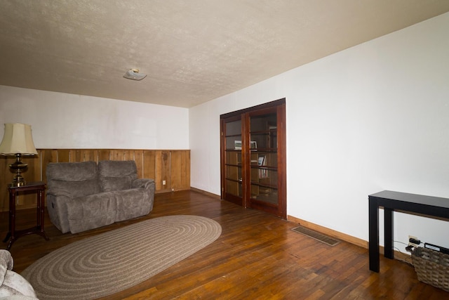534 Lower Gilmore Rd, Campton, KY 41301 - living area with wood-type flooring, wood walls, visible vents, and a wainscoted wall