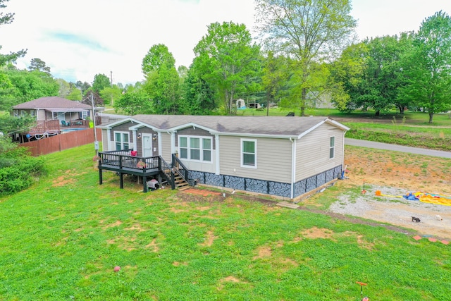 6989 W Laurel Rd, London, KY 40741 - rear view of house featuring a lawn, fence, and a wooden deck