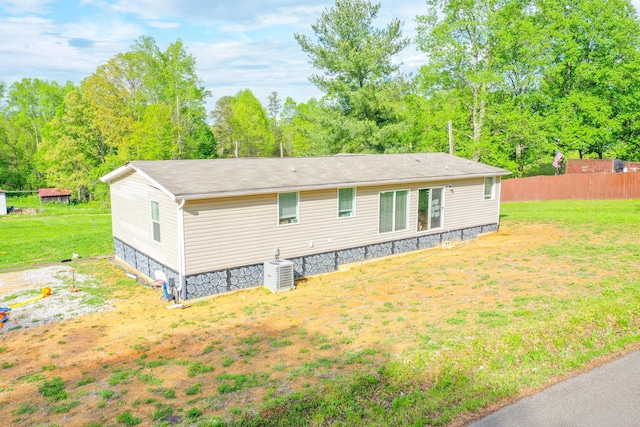 6989 W Laurel Rd, London, KY 40741 - rear view of house with fence, a lawn, and central AC