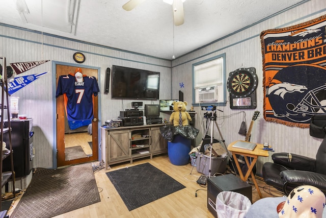 interior space with a ceiling fan, attic access, a textured ceiling, wood finished floors, and cooling unit