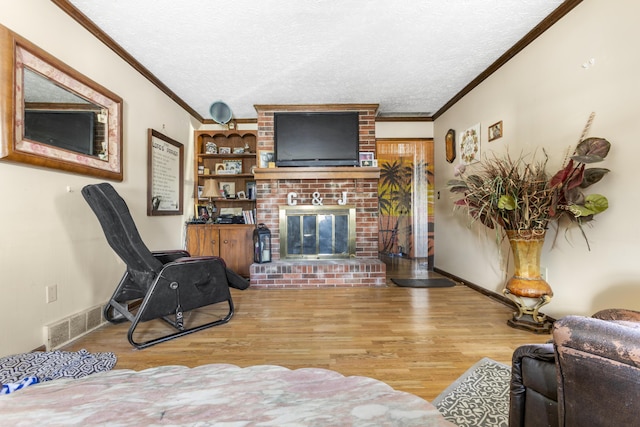 living area featuring visible vents, crown molding, and wood finished floors