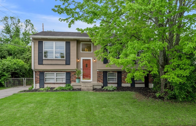 split foyer home featuring brick siding and a gate