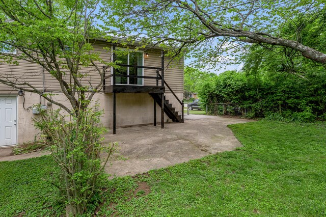 rear view of house with a lawn, a patio, and stairs