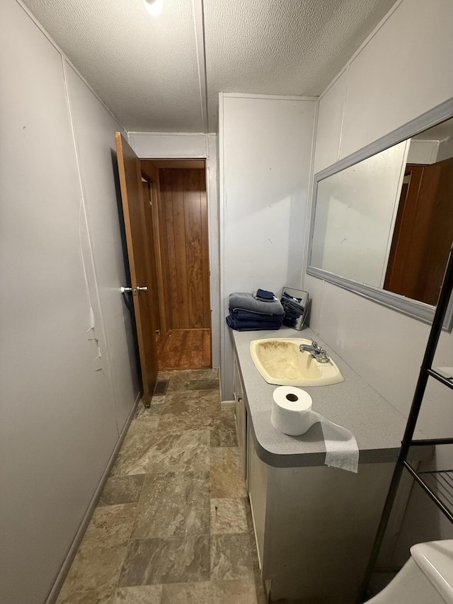 bathroom with vanity, stone finish floor, and toilet
