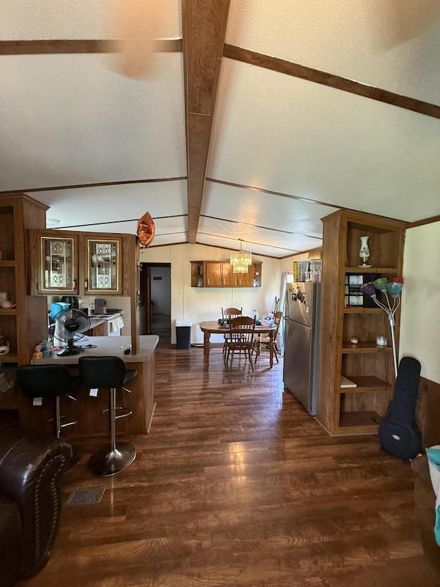 dining room featuring vaulted ceiling with beams, dark wood-type flooring, visible vents, and an inviting chandelier