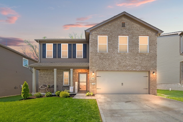 traditional-style home with a garage, a front yard, brick siding, concrete driveway, and a porch