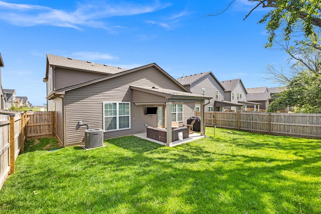 back of property with a lawn, a patio, central AC unit, and a fenced backyard
