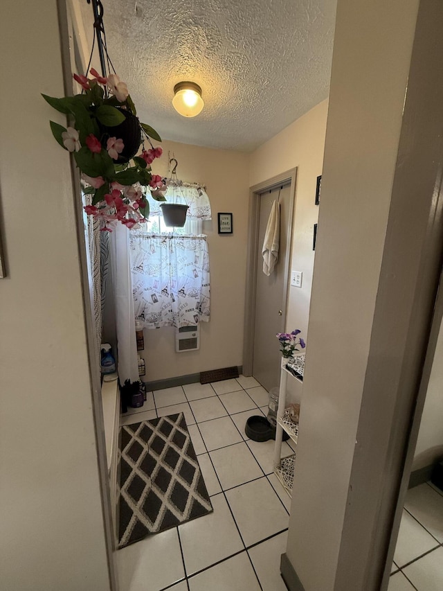 entryway with a textured ceiling and light tile patterned floors