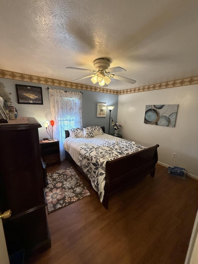 bedroom featuring a textured ceiling, baseboards, a ceiling fan, and wood finished floors