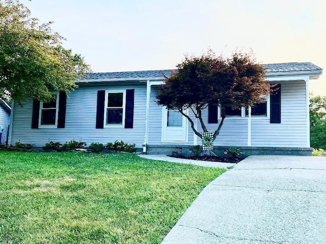 single story home featuring roof with shingles and a front lawn