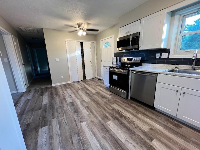 kitchen with visible vents, a sink, white cabinets, and stainless steel appliances
