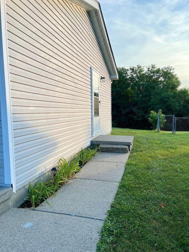 view of property exterior with fence and a yard