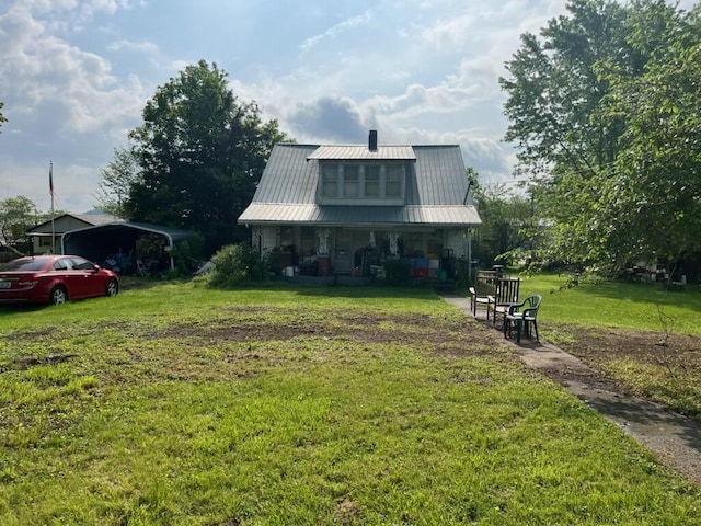 view of front of home featuring a porch, a chimney, metal roof, and a front yard