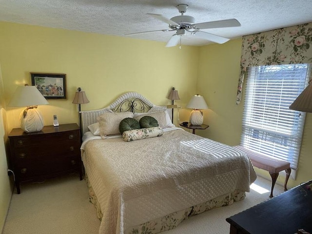 bedroom featuring a textured ceiling, ceiling fan, and carpet