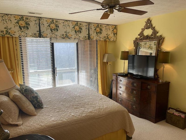 carpeted bedroom with visible vents, a textured ceiling, and ceiling fan