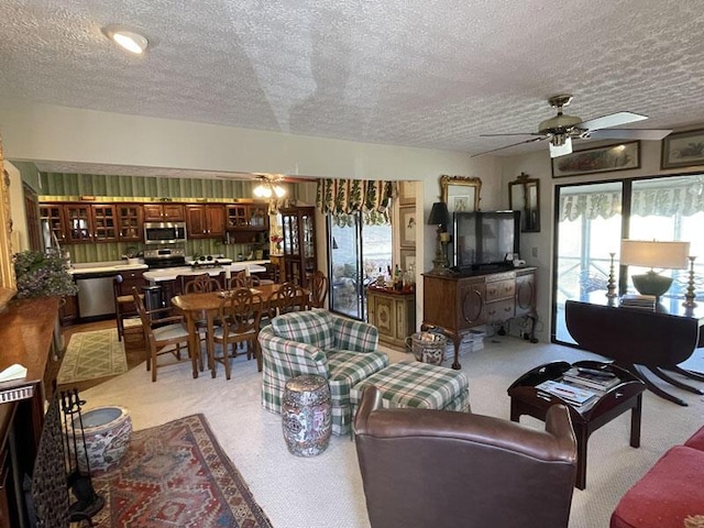 living room featuring a textured ceiling, ceiling fan, and a wealth of natural light
