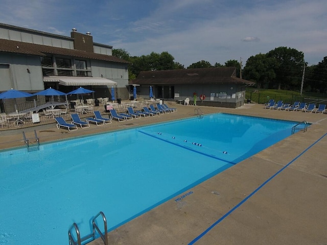 community pool with a patio and fence