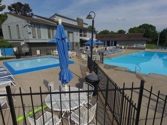 community pool featuring a patio and fence