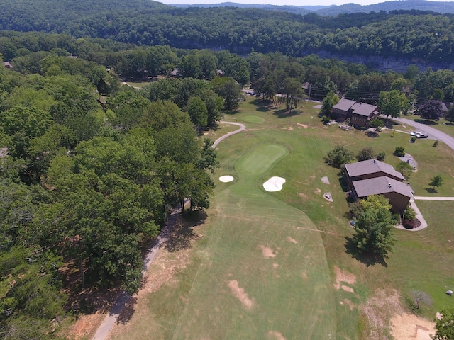 bird's eye view featuring a mountain view, golf course view, and a wooded view