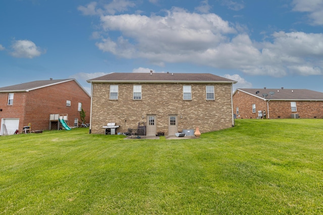 rear view of property with a yard and brick siding
