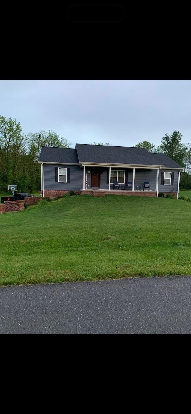 ranch-style home with covered porch and a front yard