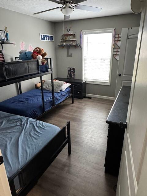 bedroom with baseboards, a ceiling fan, and wood finished floors