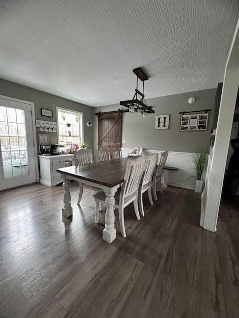 dining space with a textured ceiling and dark wood-type flooring