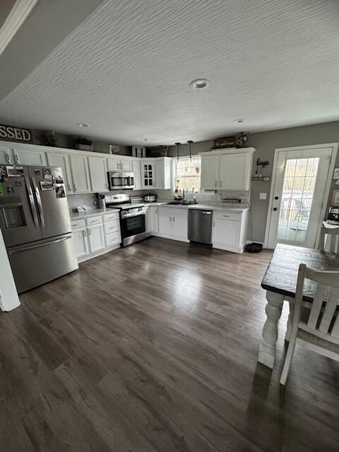 kitchen with light countertops, stainless steel appliances, a textured ceiling, and white cabinetry
