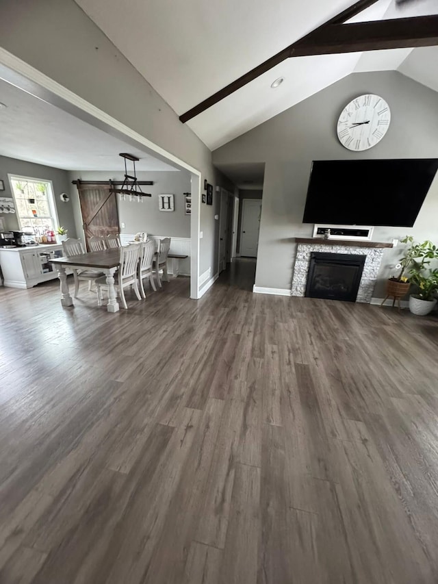 living area with a fireplace, beamed ceiling, baseboards, high vaulted ceiling, and dark wood-type flooring