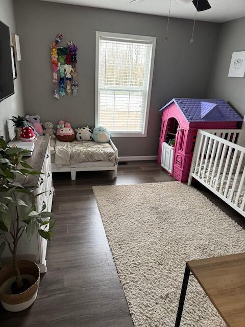bedroom featuring dark wood-type flooring, baseboards, and ceiling fan