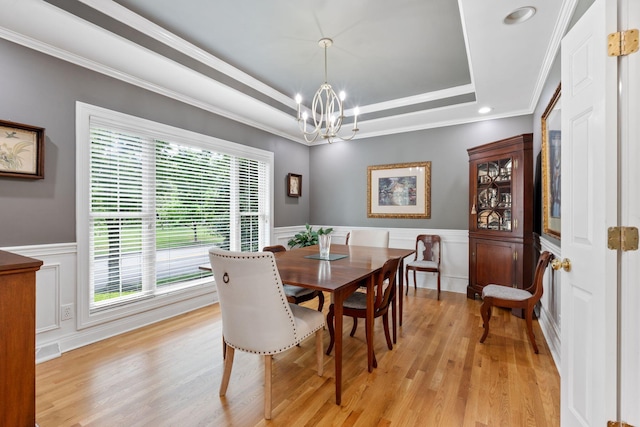 3283 Snaffle Rd, Lexington, KY 40513 - dining room featuring a chandelier, a tray ceiling, light wood finished floors, wainscoting, and a decorative wall