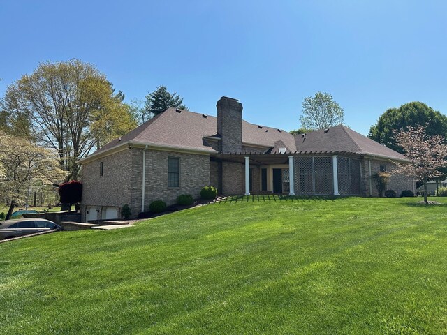 101 Wildwood Dr, Somerset, KY 42503 - rear view of property featuring a lawn, an attached garage, a chimney, and brick siding
