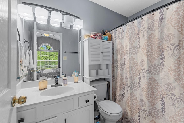 ensuite bathroom with vanity, a ceiling fan, toilet, and ensuite bath