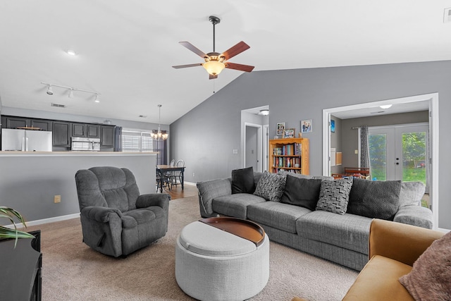 living area with lofted ceiling, light carpet, baseboards, french doors, and ceiling fan with notable chandelier