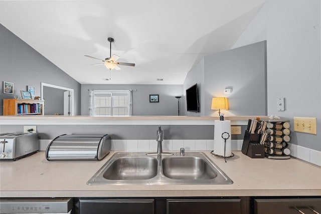 kitchen with a sink, dishwasher, light countertops, a ceiling fan, and lofted ceiling