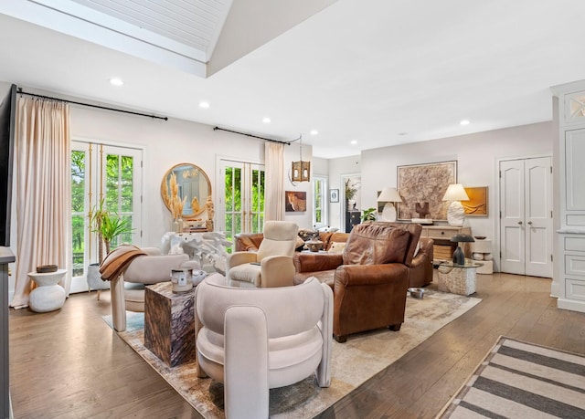 living area with recessed lighting, light wood finished floors, and vaulted ceiling