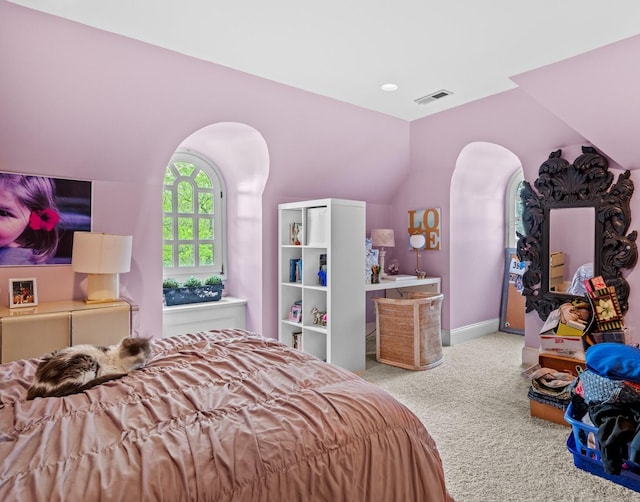 carpeted bedroom featuring visible vents, arched walkways, baseboards, and vaulted ceiling
