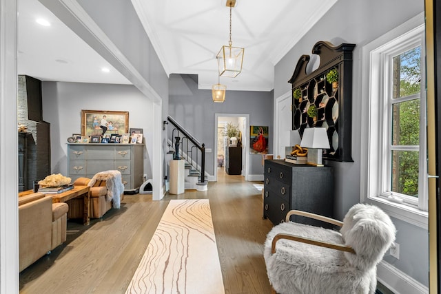 foyer entrance with stairs, baseboards, ornamental molding, and wood finished floors