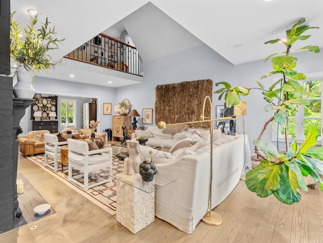 living room featuring a high ceiling, wood finished floors, and a fireplace