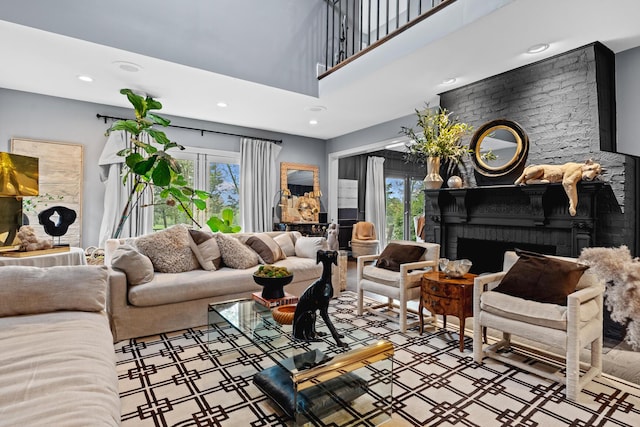 living room with recessed lighting, a towering ceiling, and a fireplace