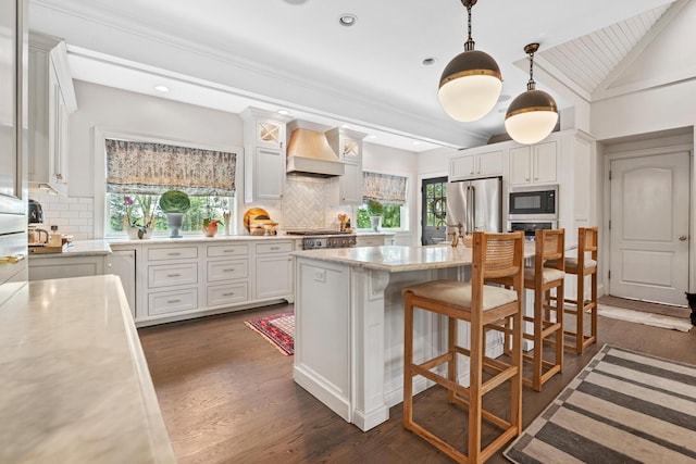 kitchen with high end fridge, decorative backsplash, built in microwave, and premium range hood