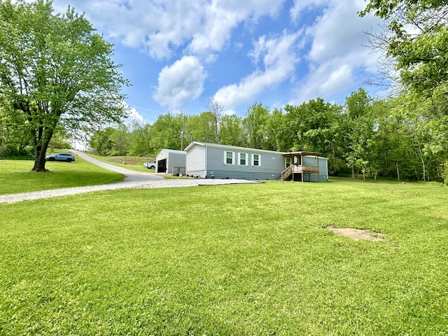 view of yard with a wooden deck and gravel driveway