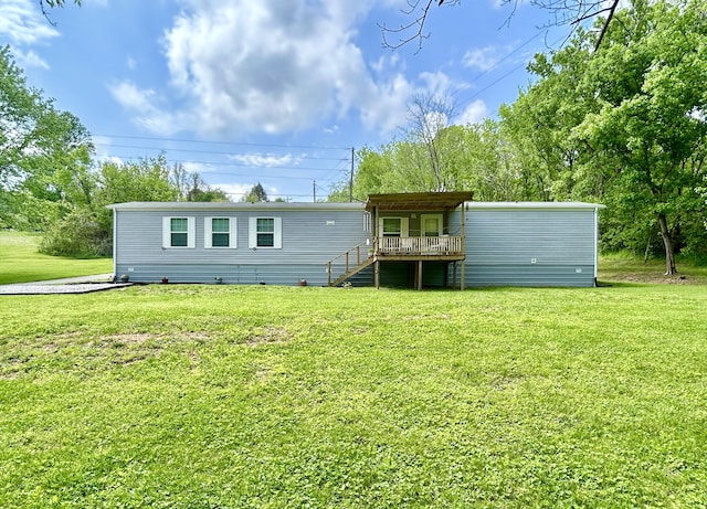 rear view of property featuring a yard, a wooden deck, and stairs