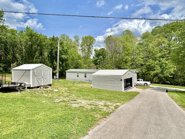 view of yard featuring fence, a storage unit, an outdoor structure, and a garage