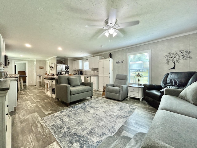 living area featuring recessed lighting, a ceiling fan, wood finished floors, and ornamental molding