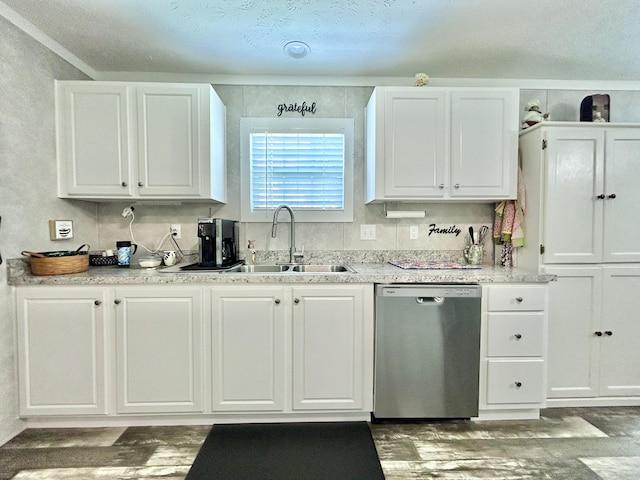 kitchen with stainless steel dishwasher, a sink, wood finished floors, and white cabinets