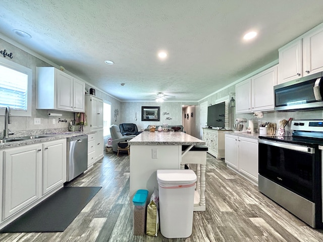 kitchen featuring a sink, white cabinetry, appliances with stainless steel finishes, and a healthy amount of sunlight
